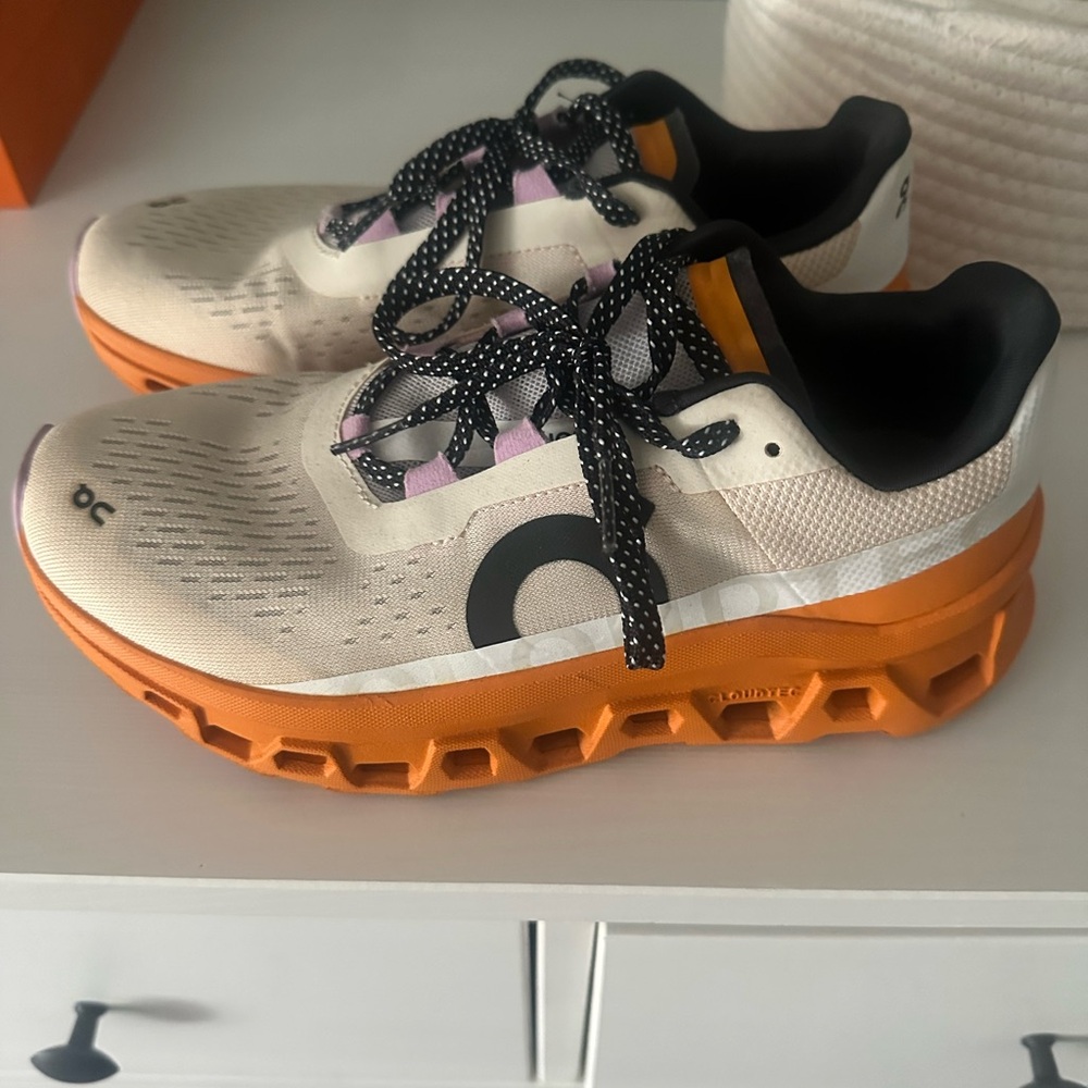On Running Cream and Orange Athletic Shoes with Vibrant Outsole